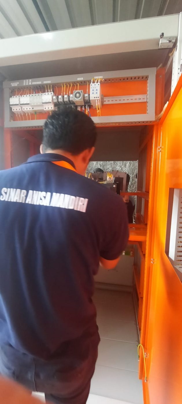 Teknisi mengerjakan panel listrik